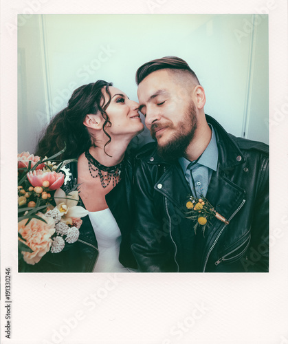 Wedding in the style of rock. Rocker or Biker wedding. Guys with stylish leather jackets. It's a rock'n'roll baby! The sweet couple are photographed in a photobooth. Photo in the style of Polaroid.