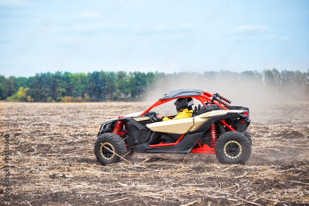 Quad bike with driver in helmet rushes across the field Quad bike with driver in helmet rushes across the field