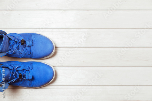 pair of blue sneakers on wooden background flat view
