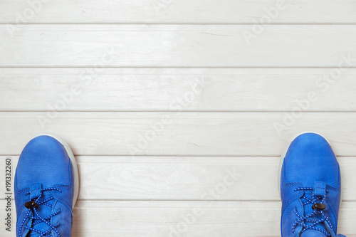 pair of blue sneakers on wooden background flat view