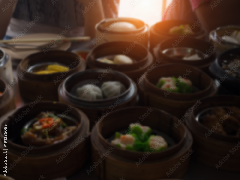 The blurry light design background of Chinese food ,Dimsum in bamboo basket.put on table,at  chinese food reataurant.