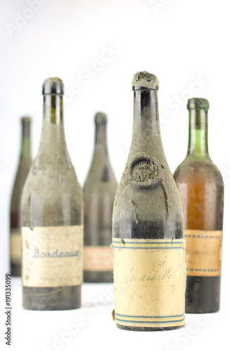 group of old vintage bottles of wine completely dusty photo