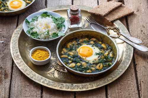 Persian breakfast with eggs, bean and dill in copper pan photo