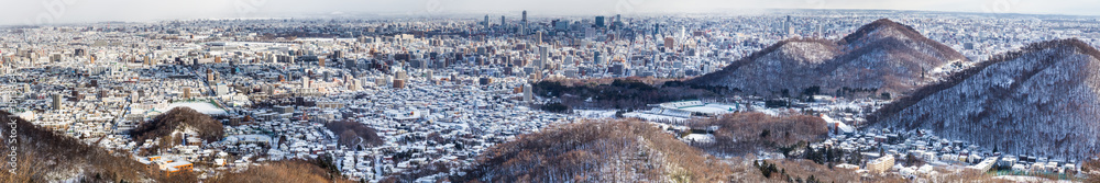 Fototapeta premium Panorama aerial view of Sapporo city during winter with snow
