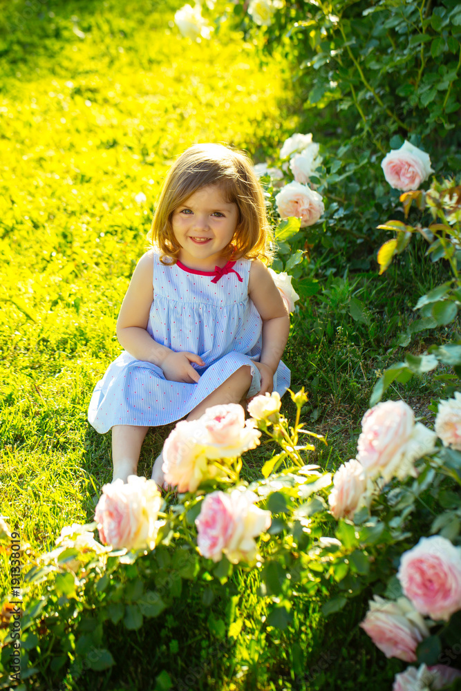 Baby girl with cute smile sitting on green grass Baby girl with cute smile sitting on green grass