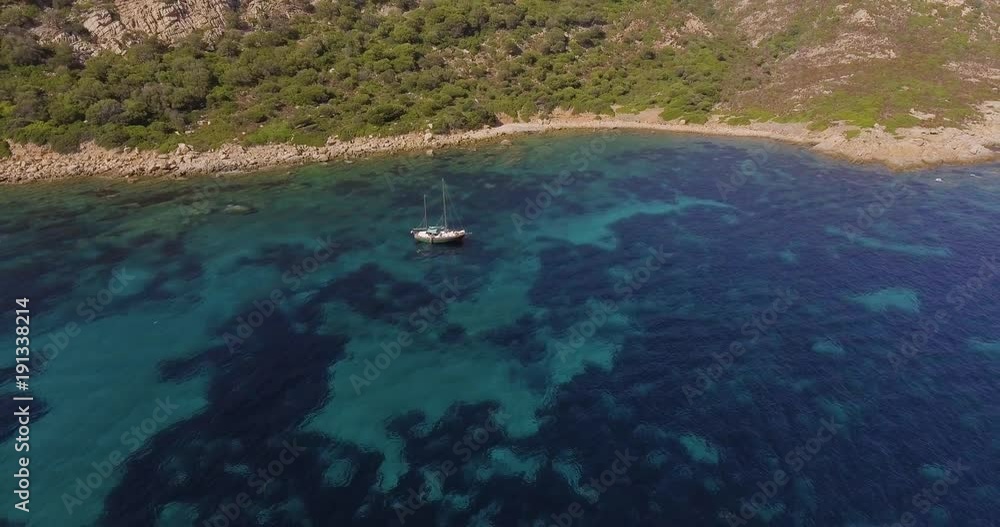 Aerial, a lonely sailing ship in a beautiful bay with crystalline water Aerial, a lonely sailing ship in a beautiful bay with crystalline water