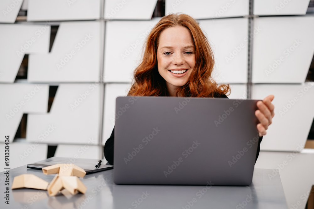 Young red-haired woman sitting in front of laptop Young red-haired woman sitting in front of laptop