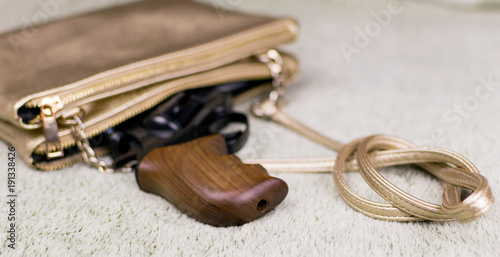 Female self-defense. A pistol peeping out of a woman's handbag.