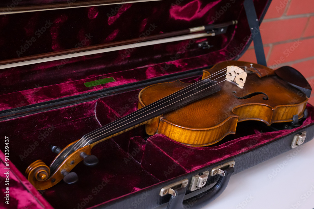 Violin and bow in dark red case.