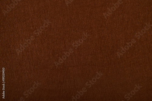 Fragment of the surface of fibrous synthetic non-woven material of brown color. Background, texture