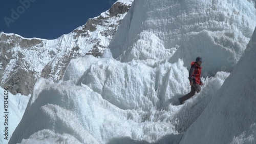 The Khumbu Glacier descends from Mount Everest. Walking on the glacier is very dangerous. The girl climbs the glacier. Nepal. Himalayas. 4K