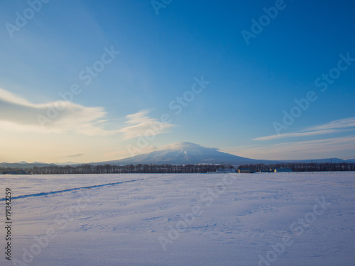 朝日の雪原と雪山