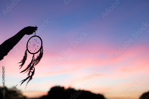 Silhouette of Dream Catchers hold up in the air during sunset period