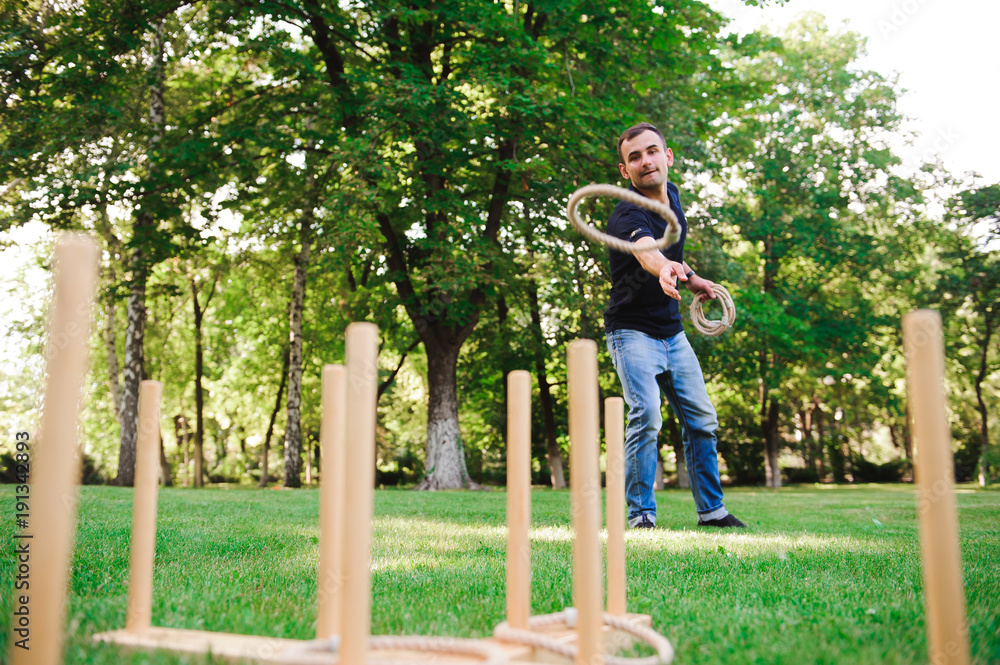 Obraz premium Boy playing a game throwing rings outdoors in summer park