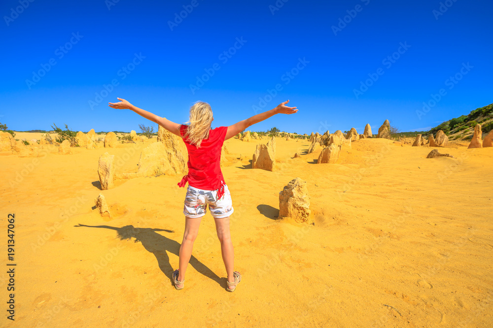 Western Australia travel freedom concept. Carefree woman with open arms watching the desert of Pinnacles limestone in Nambung National Park of Cervantes, in WA state of Australia