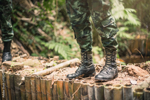 Photo from back of soldier. Soldier on mission in forest.