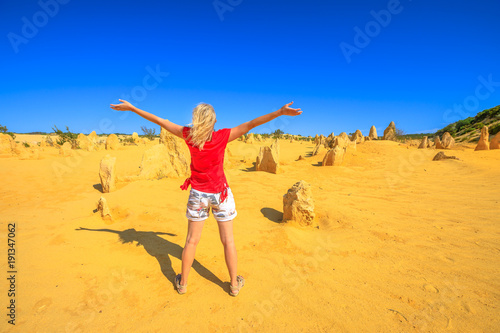 Western Australia travel freedom concept. Carefree woman with open arms watching the desert of Pinnacles limestone in Nambung National Park of Cervantes, in WA state of Australia