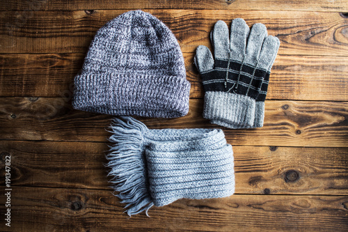 grey winter hat gloves scarf on a wooden bacground