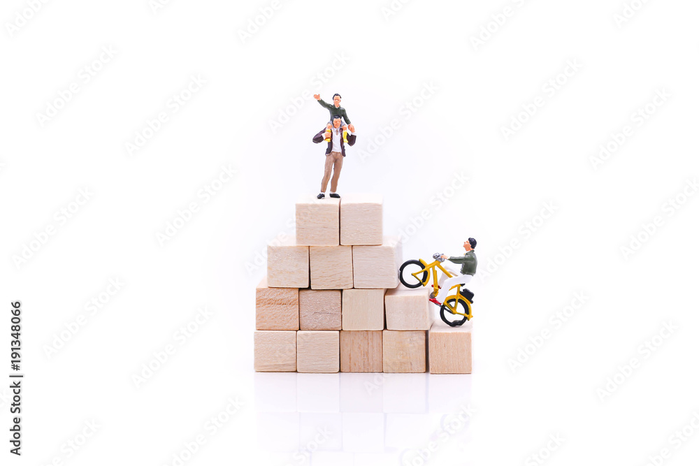 Miniature people : man ride bicycle on stack of wooden block. Miniature people : man ride bicycle on stack of wooden block.