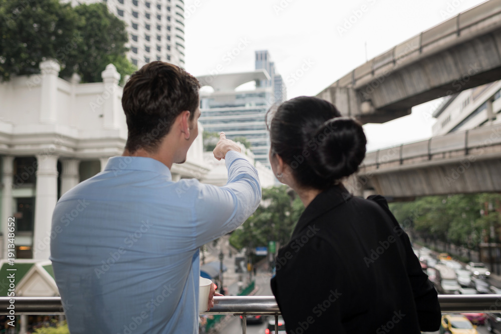Two business colleagues in street city walk and talking to each other.City sightseeing concept. Two business colleagues in street city walk and talking to each other.City sightseeing concept.