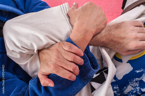 Brazilian jiu jitsu instructor demonstrates ground fighting arm lock techniques photo