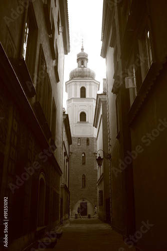St. Martin's Church Bell Tower In Warsaw seen at the end of an alley. Black and white. photo