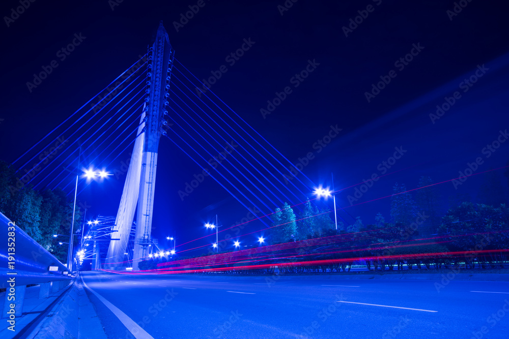 Obraz premium lights trails from cars in business center bridge