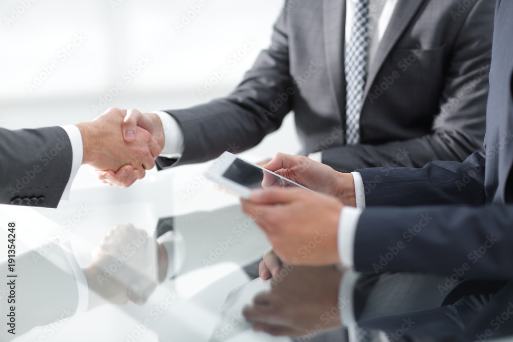 Two confident businessmen shaking hands during a meeting in the Two confident businessmen shaking hands during a meeting in the