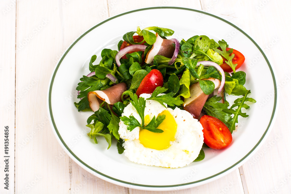 Fresh vegetable salad with ham and fried egg Fresh vegetable salad with ham and fried egg