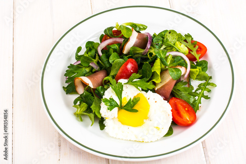 Fresh vegetable salad with ham and fried egg
