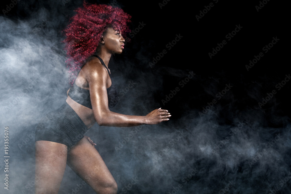 A strong athletic, female sprinter, running at sunrise wearing in the sportswear, fitness and sport motivation concept with copy space.