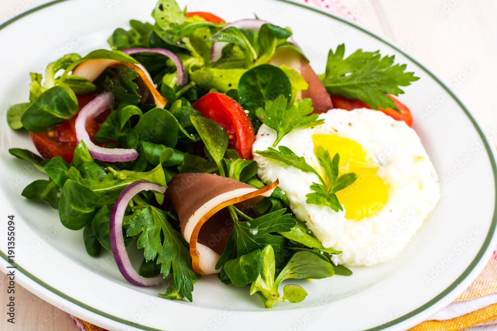 Fresh vegetable salad with ham and fried egg Fresh vegetable salad with ham and fried egg