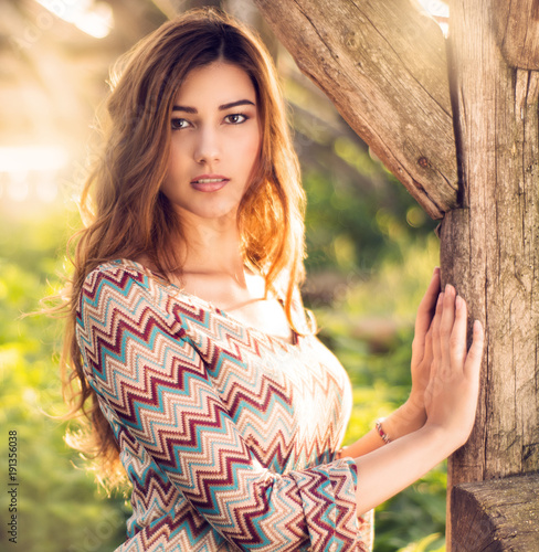 Young happy attractive woman posing in sunset