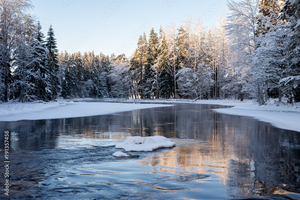 Obraz premium Sunrise river in a cold winter landscape with snow and frost.
