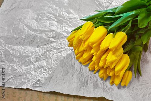 Fresh flower composition, bouquet yellow tulips on craft paper background. Valentine, Women's, 8 march, birthday, mother's day present. Copy space, close up, top view. photo