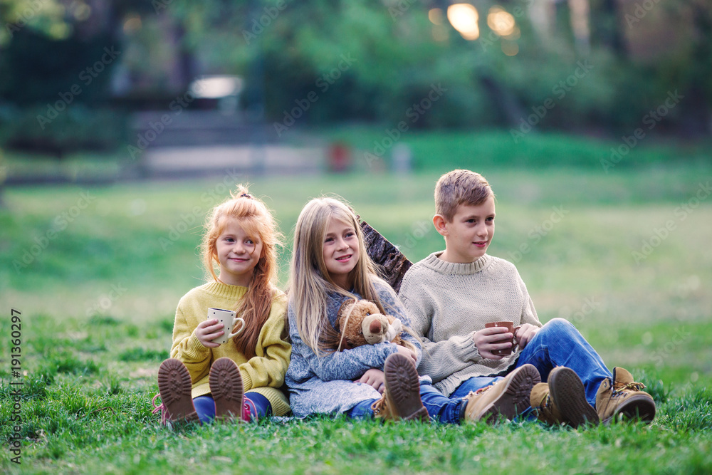 Kids sitting on the grass in the park Kids sitting on the grass in the park