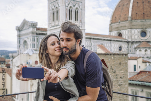 Loving couple taking a selfie in front of the church Santa Maria del Fiore, Florence Cathedral © loreanto