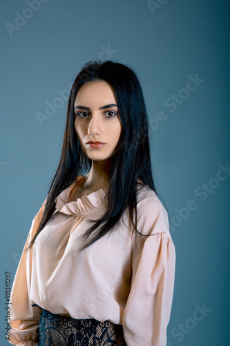 Portrait of Beautiful brunette businesswoman over blue grey background