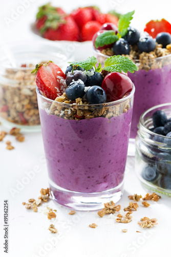 Blueberry dessert with granola on a white background, vertical
