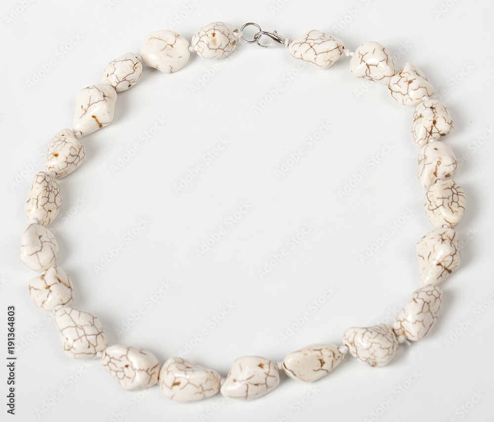 Fototapeta premium Necklace with stones on a white background. Bijouterie. Women's accessories. Necklace on the neck. Valuable jewelry.Decorating for women.Women's accessories isolated white background