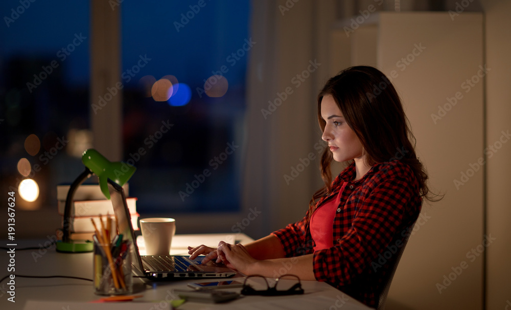 Fototapeta premium student or woman typing on laptop at night home