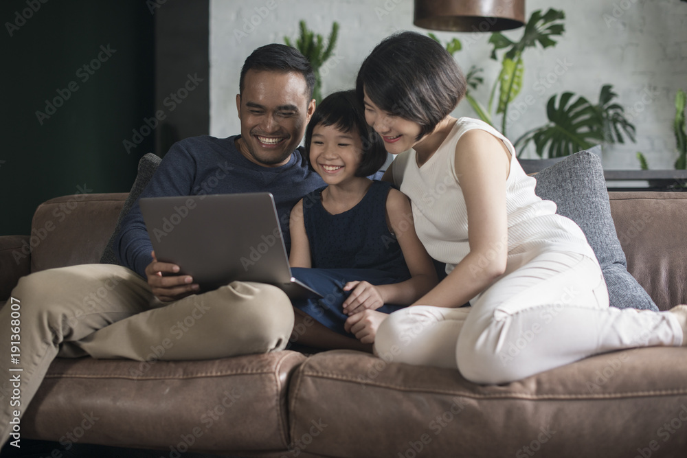 Happy Asian family using the computer together at home. Happy Asian family using the computer together at home.