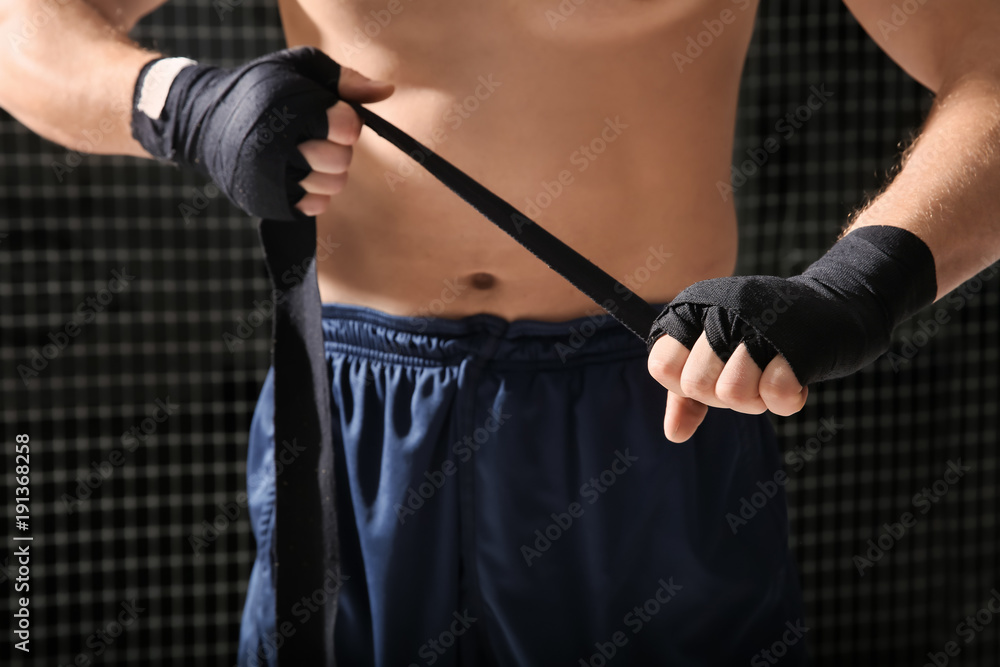 Young boxer applying wrist wraps in gym, closeup Young boxer applying wrist wraps in gym, closeup