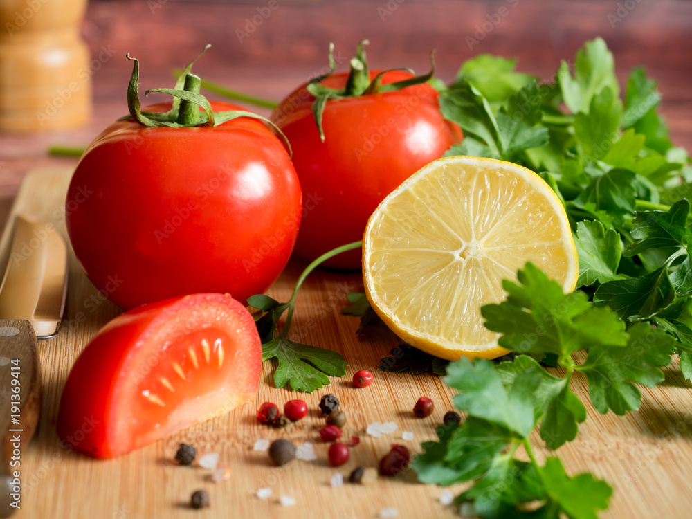 Fresh vegetables Tomatoes Lemon Parsley Pepper coarse Salt on a cutting Board Fresh vegetables Tomatoes Lemon Parsley Pepper coarse Salt on a cutting Board