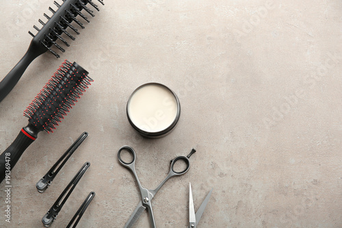 Professional hairdresser's tools and clay for hair on grey background