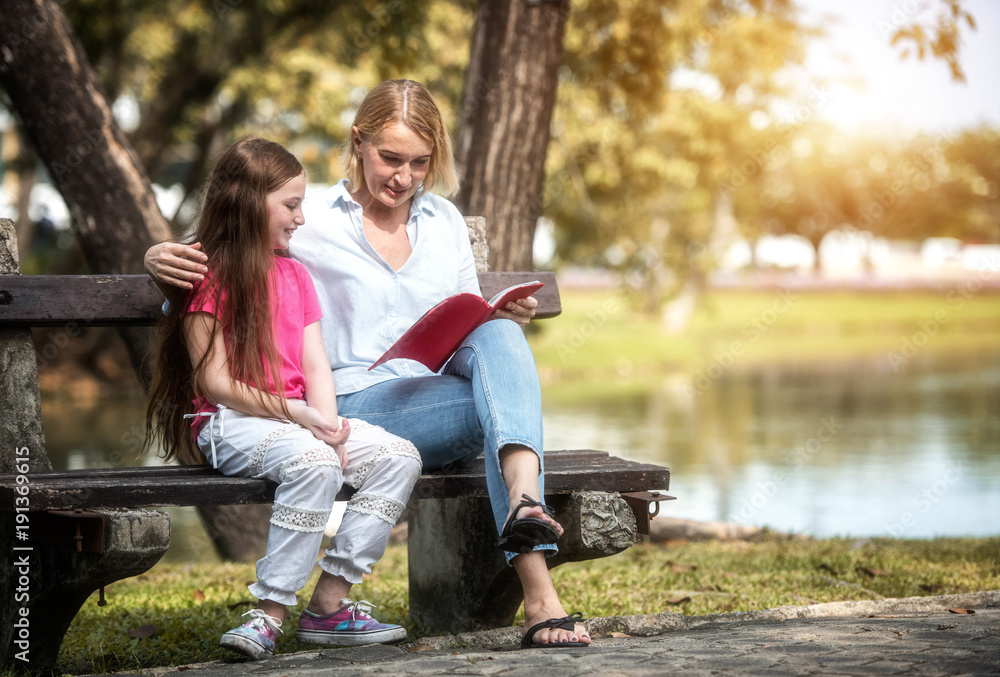 Family is reading happily together in the garden.Soft focus concept. Family is reading happily together in the garden.Soft focus concept.
