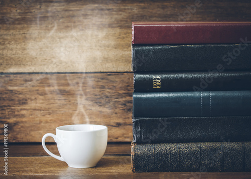 Canvas Print a cup of coffee and  stack of book with  holy bible on wooden background