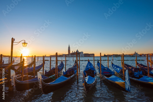 Gondolas. Venice Italy seafront with gondolas and church on background at sunrise. © nevodka.com