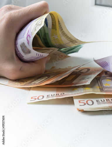 Crushing with a hand a five hundred euros banknote. photo