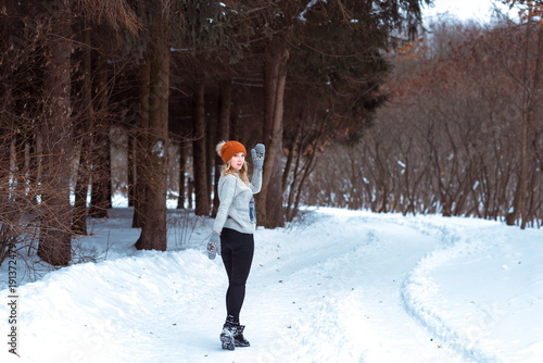 beautiful girl in a fur vest walks in a field in the snow